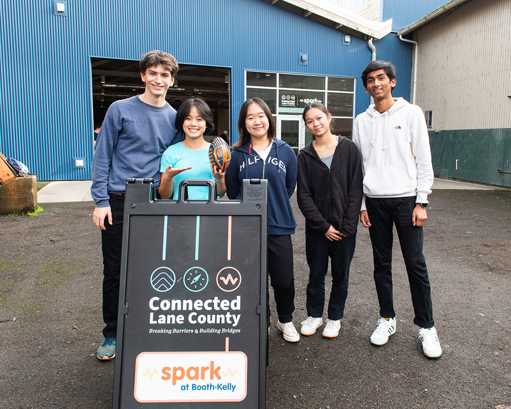 Group photo of Connected Lane County youth with sign