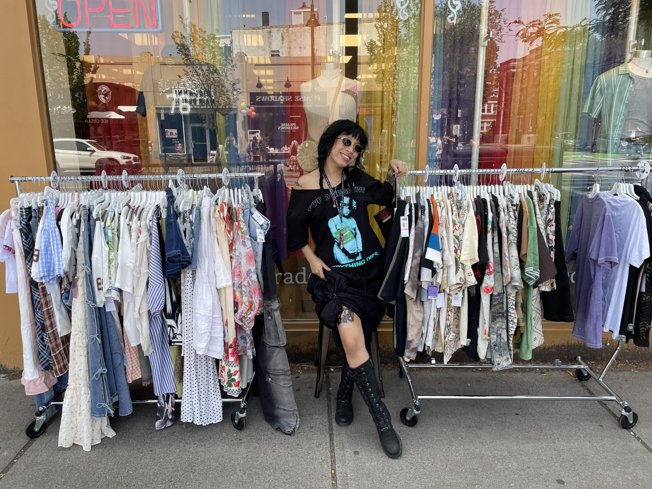 Buffalo Exchange employee Kat standing in front of a Buffalo Exchange and clothing racks