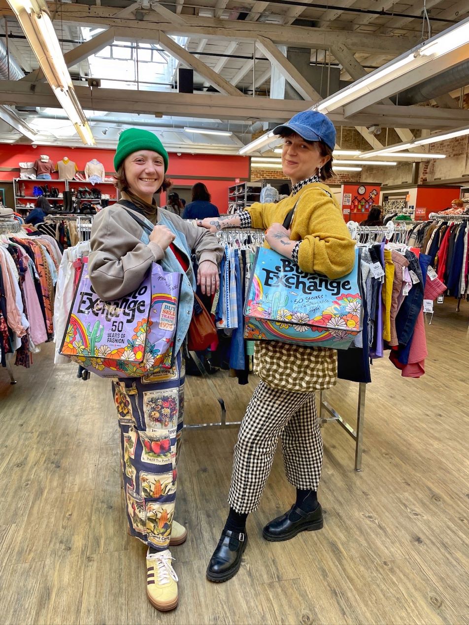 Customers in a Buffalo Exchange holding filled Buffalo Exchange tote bags